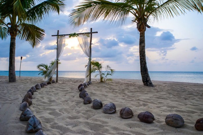 A beachfront wedding arch at sunset at Galley Bay Resort & Spa Antigua