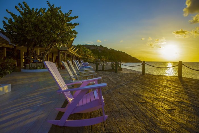 A couple relaxing on the beach at sunset at Galley Bay Resort & Spa Antigua