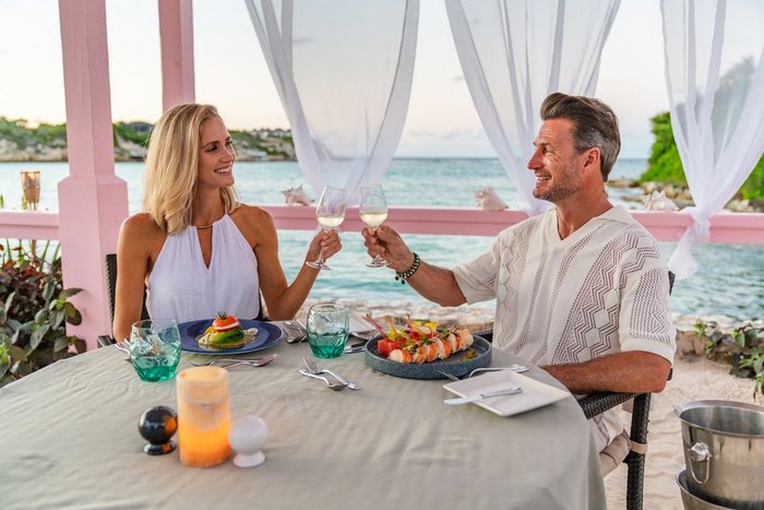 A couple toasting at a private gazebo dinner at Hammock Cove Antigua