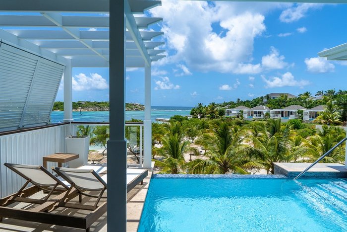 A Signature Villa bedroom and kitchenette at Hammock Cove Antigua