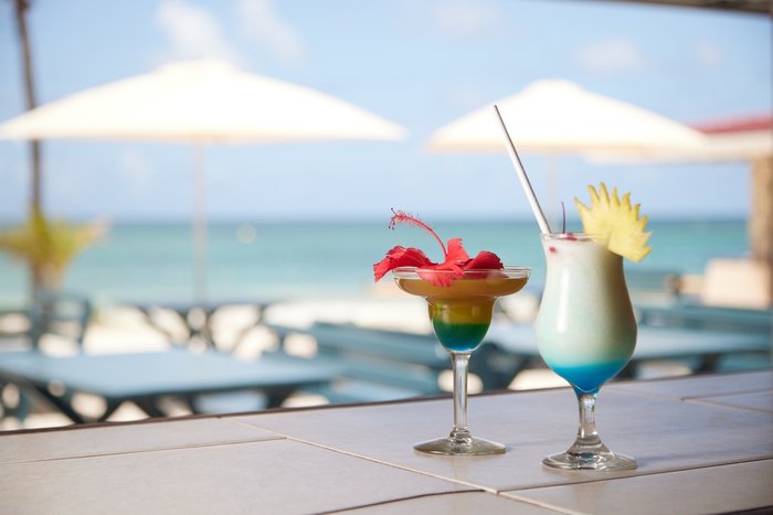 Beach chairs beneath palm trees at Pineapple Beach Club Antigua