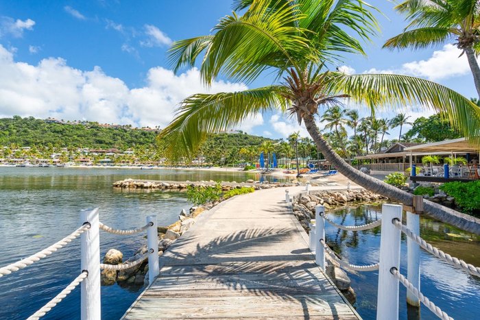 Sailboats and palm trees on the white-sand beach at St. James's Club & Villas Antigua