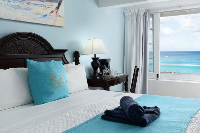 A private oceanfront-suite balcony with a table set for morning coffee at The Club Barbados