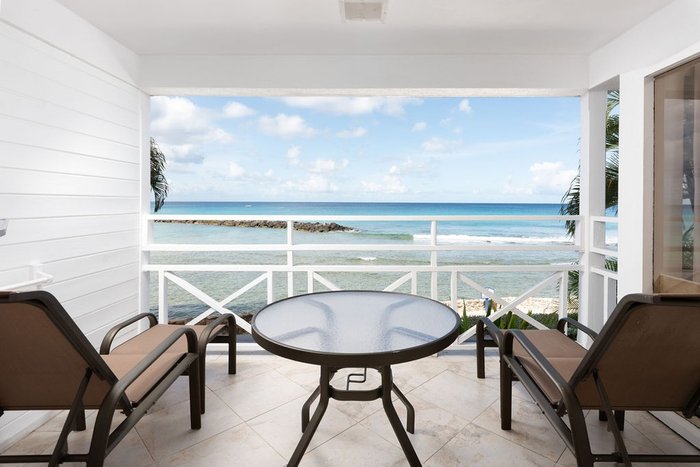 The tropical beach and palm-lined oceanfront at The Club Barbados