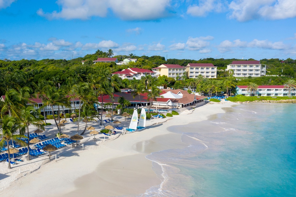 Aerial view of Pineapple Beach Club Antigua's quarter-mile white-sand beach and turquoise waters
