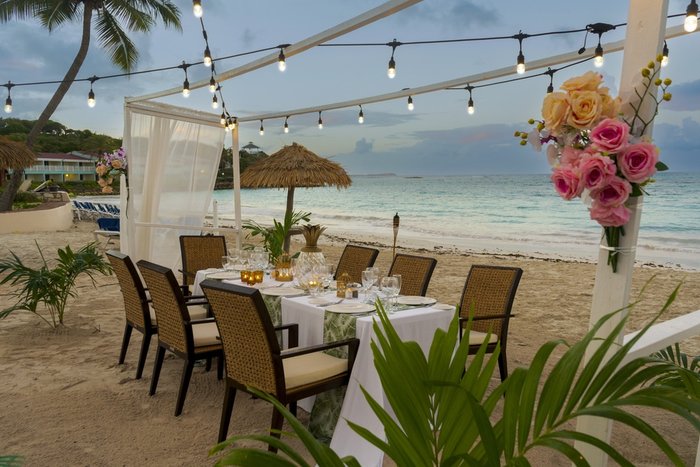 A couple toasting champagne on Long Bay Beach at Pineapple Beach Club Antigua