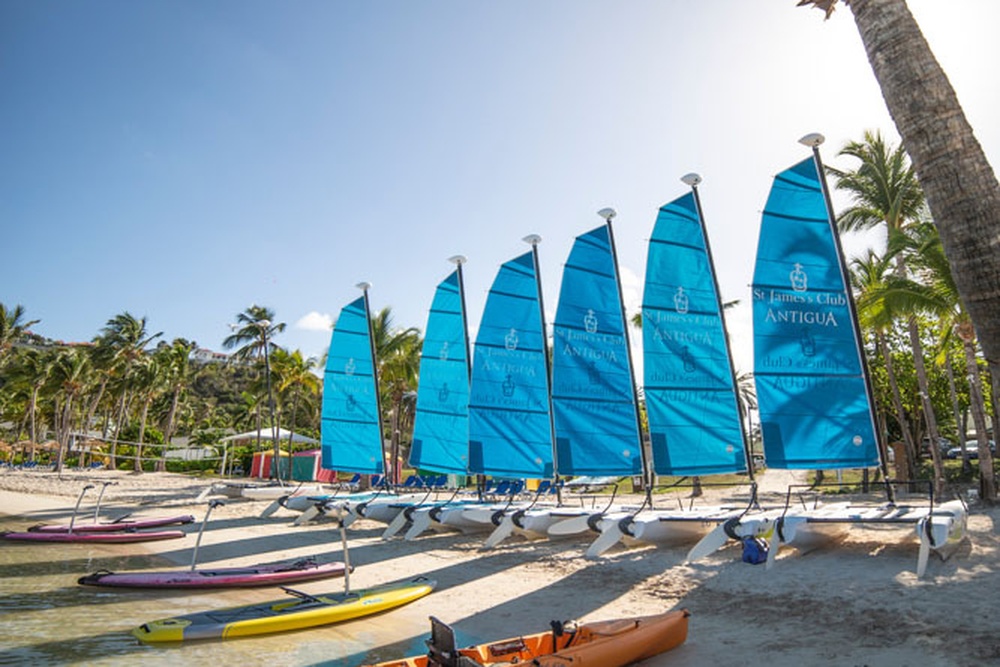 Hobie Cat sailboats lined up on the white-sand beach at St. James's Club & Villas Antigua